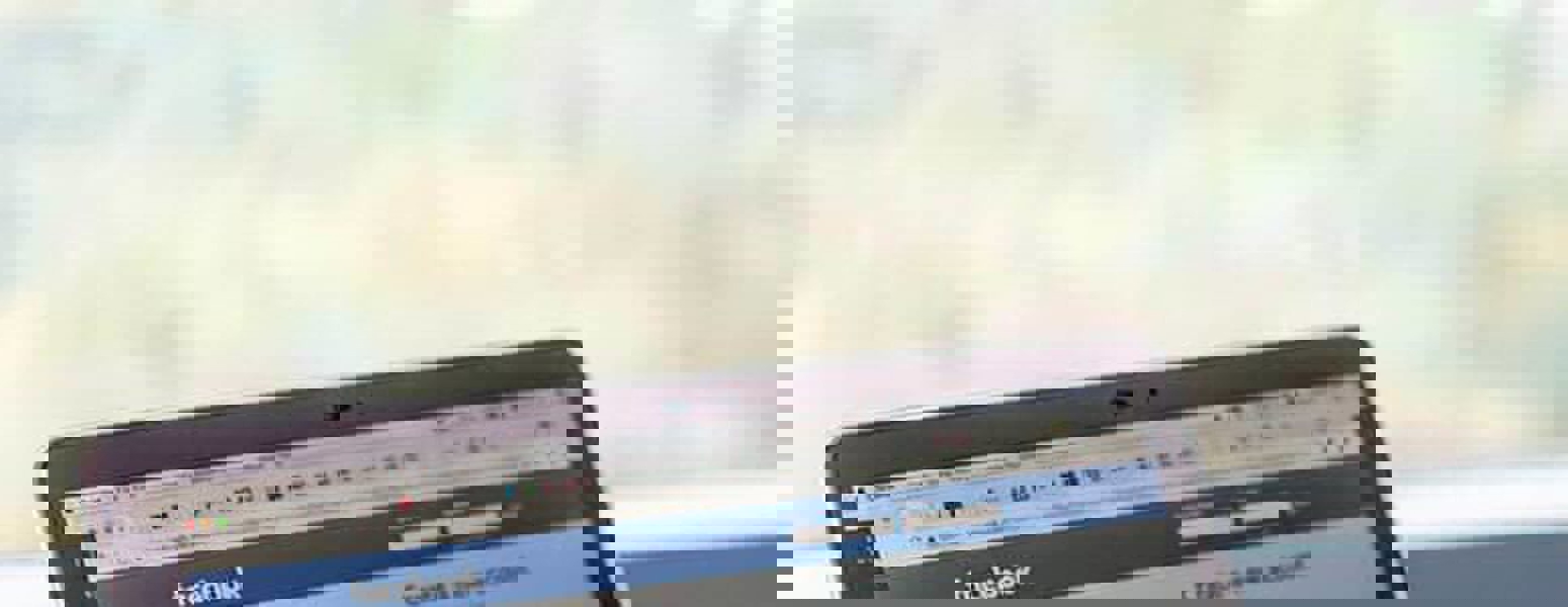 image of mobile device being held next to laptop