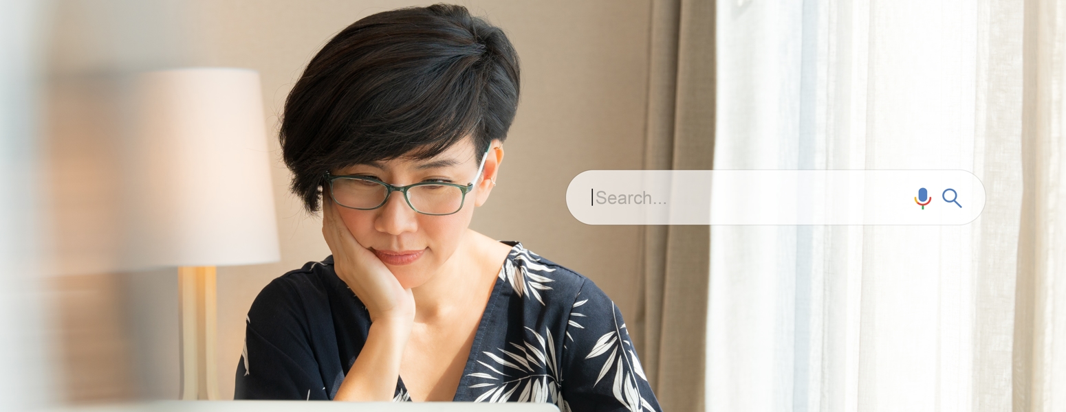 A person looking at the computer screen with a search bubble icon
