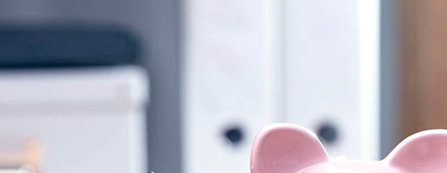 Person using Calculator in front of Piggy Bank