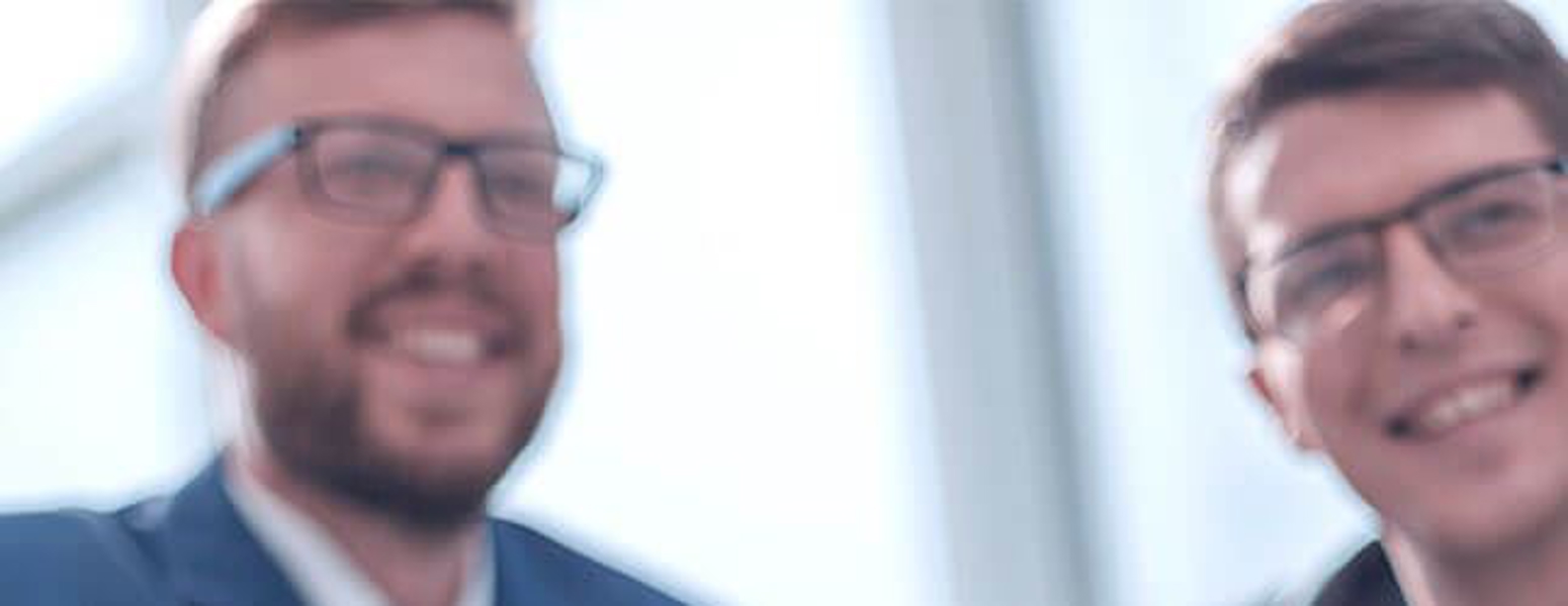 man in a suit shaking another business person's hand