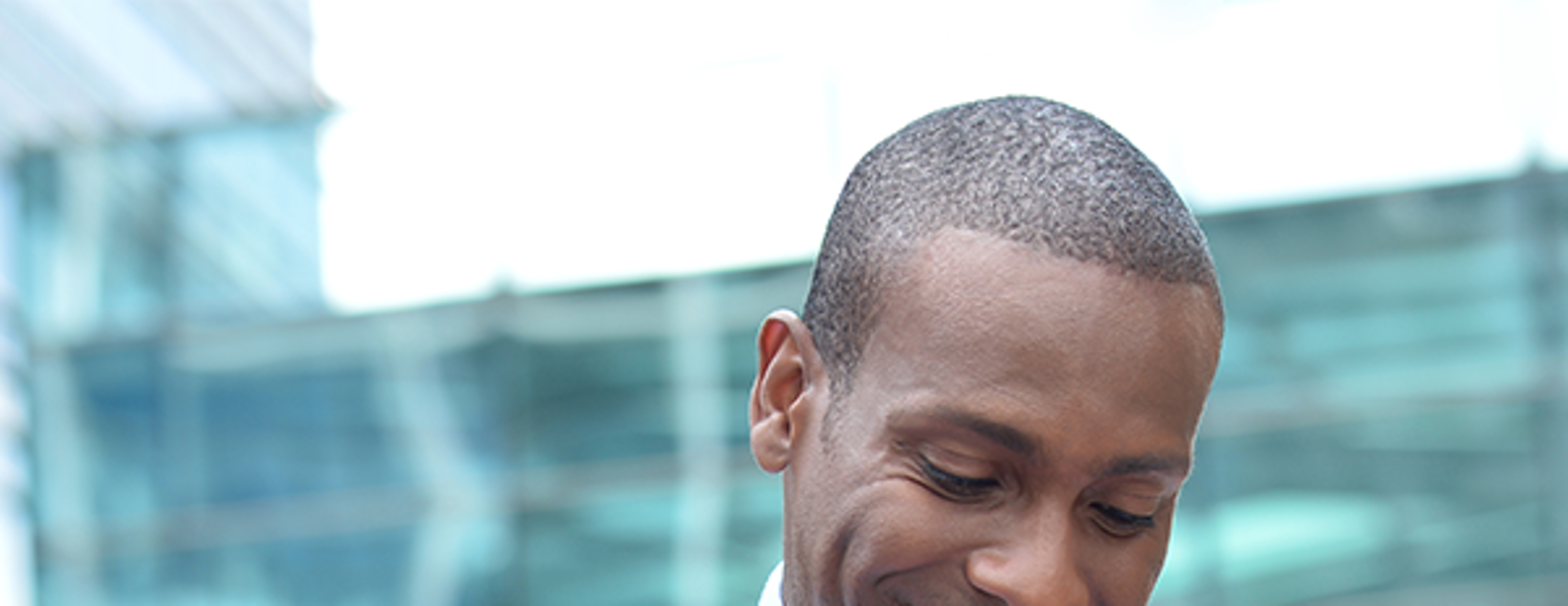Attorney outside smiling and looking at his smartphone