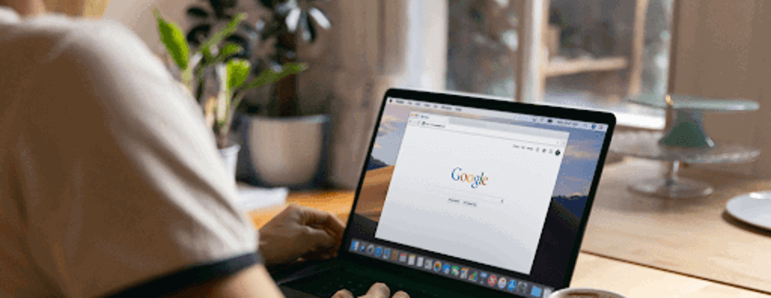 Person learning how to delete a Google review on a laptop with coffee next to it.