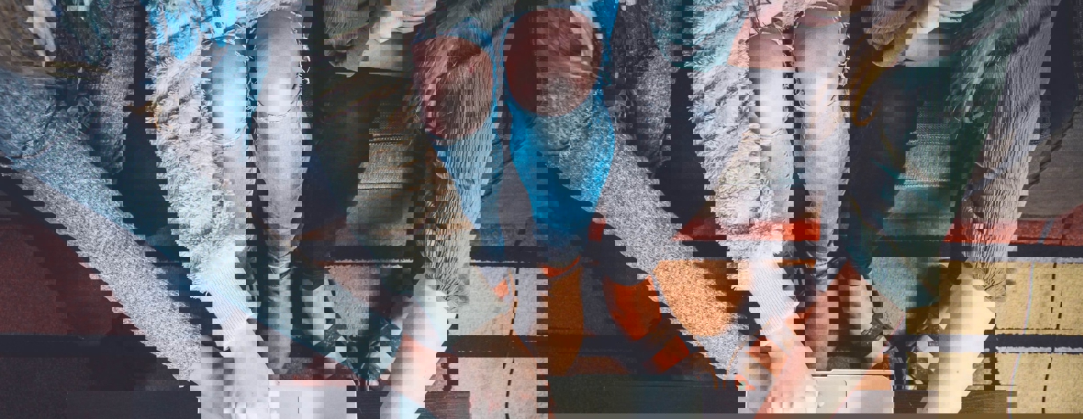 Three people point at a laptop screen while shopping online