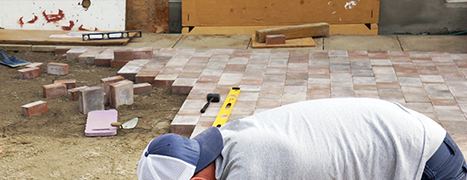 Man laying down bricks