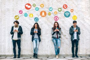 4 people on their phones in front of a wall with images