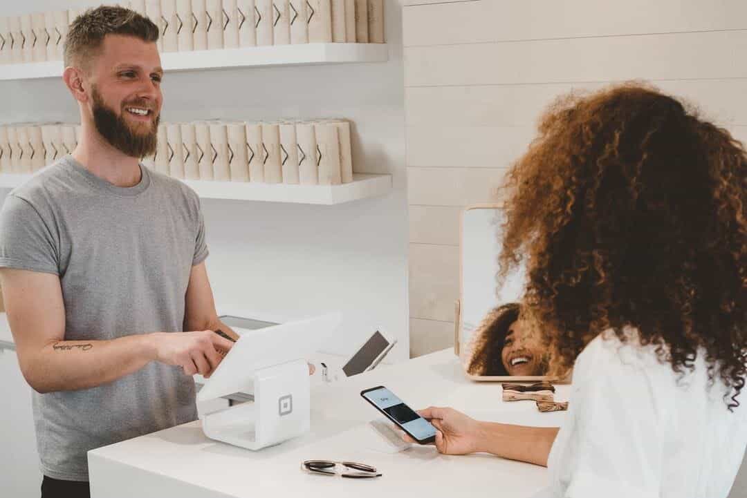 Business Owner Assisting a Customer With Phone