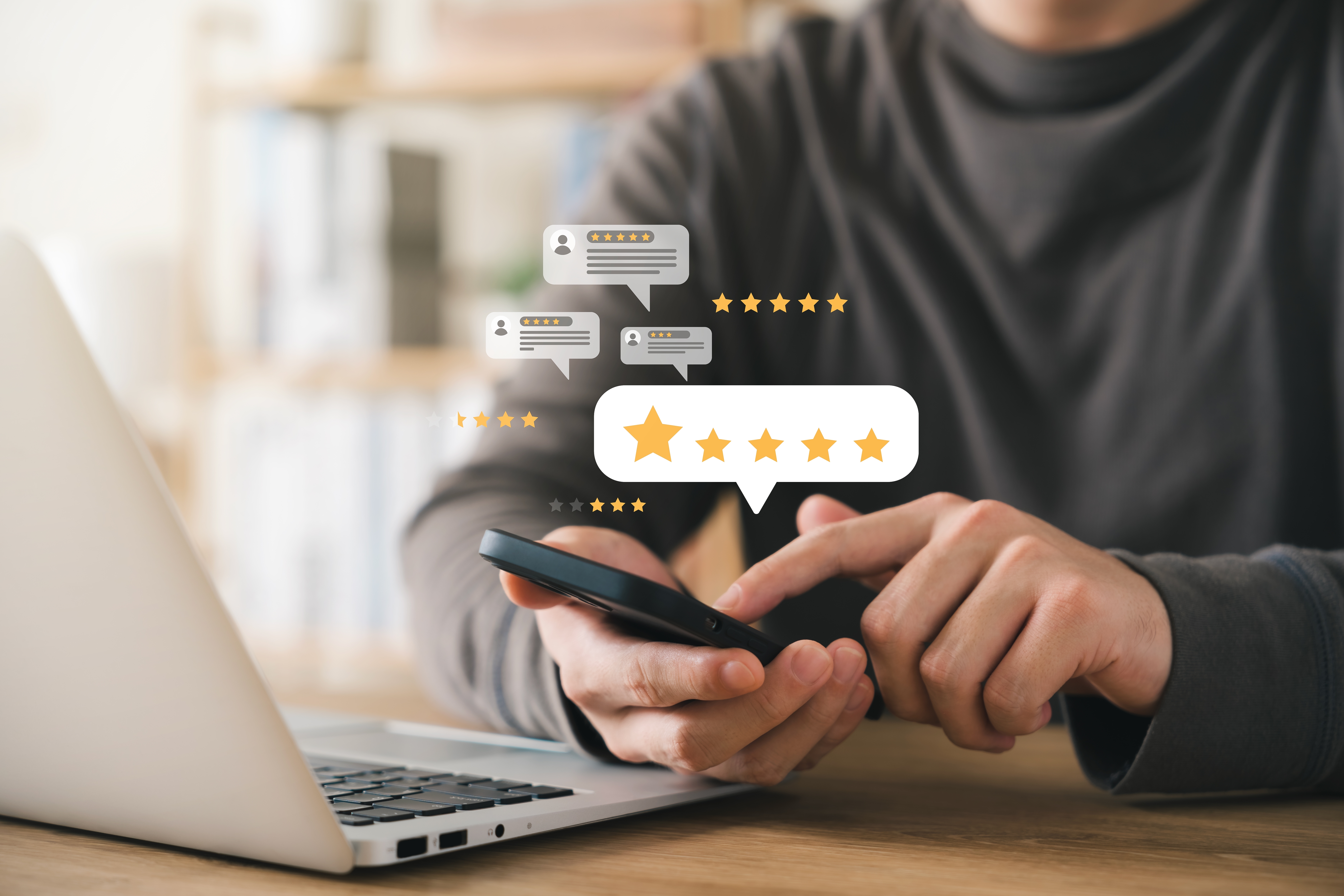 A person writing a review on their mobile phone with icons of stars around it