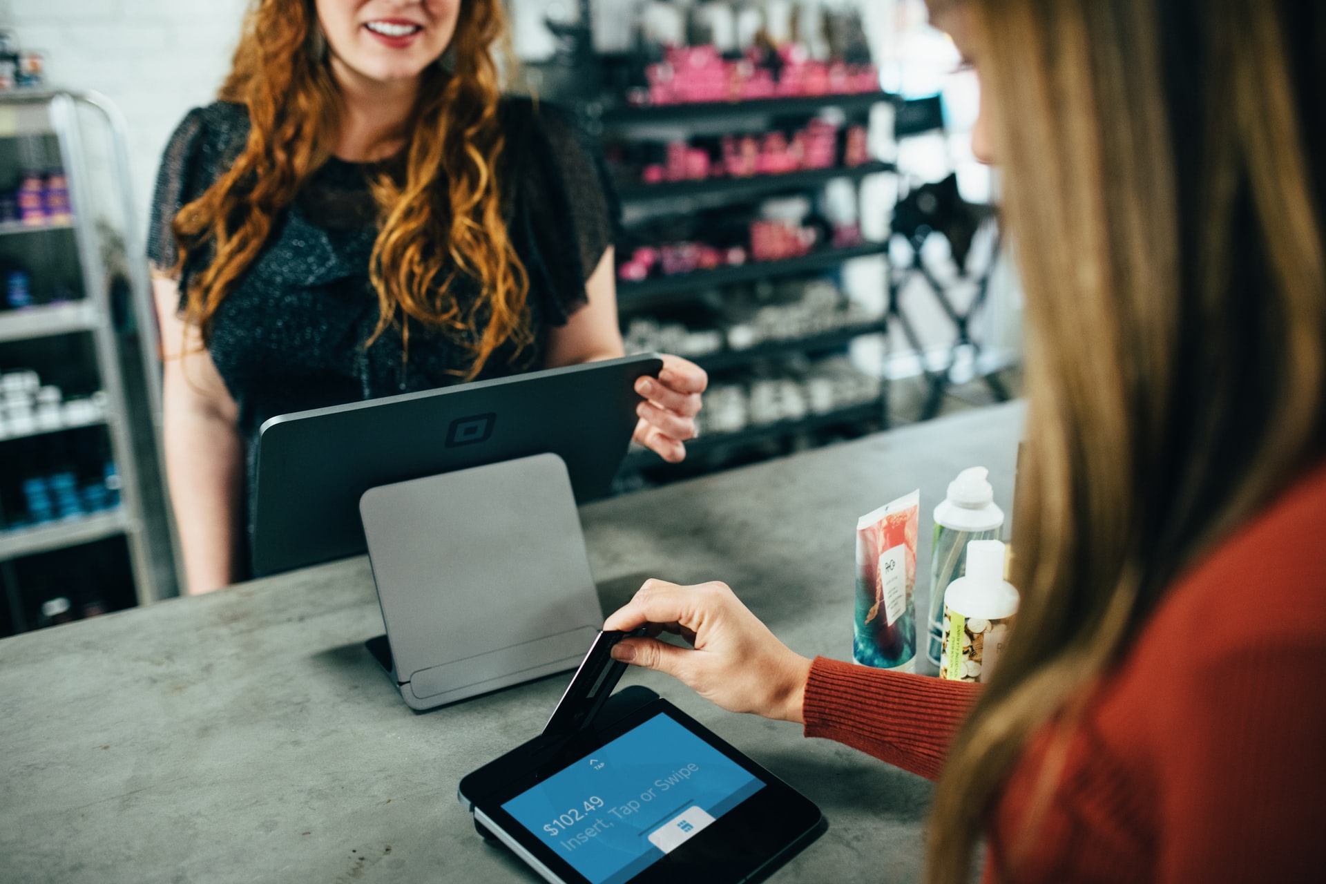 Woman pays for a product with a card reader. 