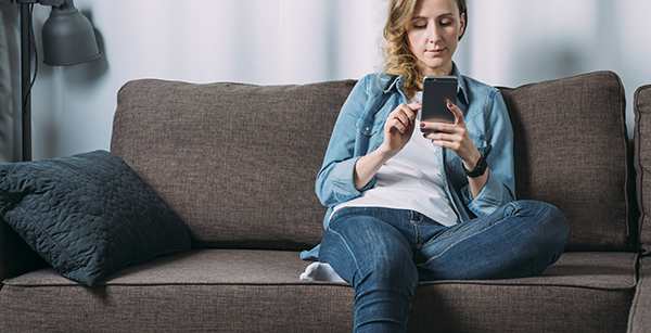 woman on the couch searching on her phone.