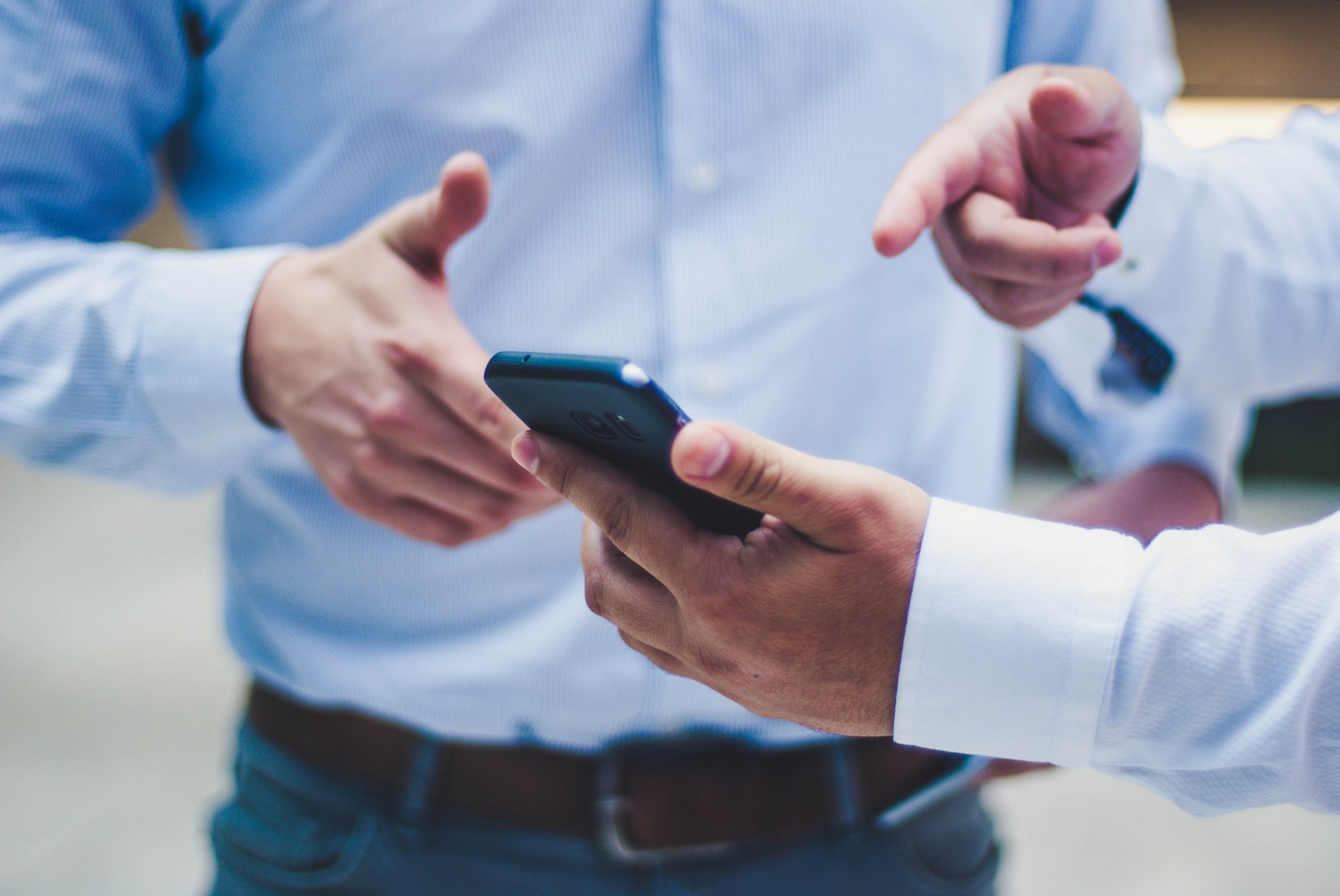 Two men consult information on a phone