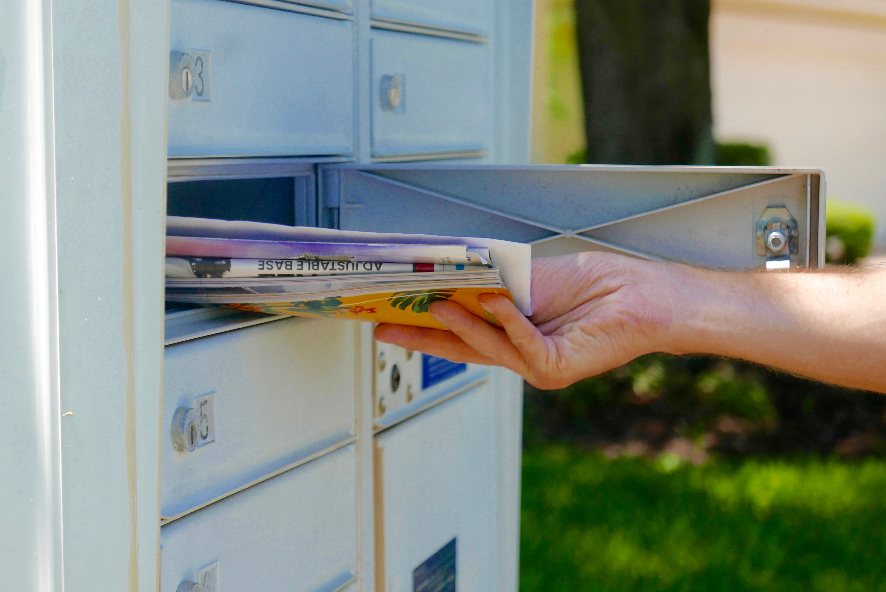 someone pulling mail out of their mailbox 