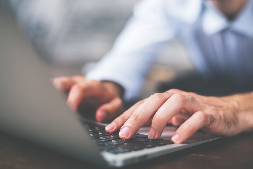 image of man typing on laptop 